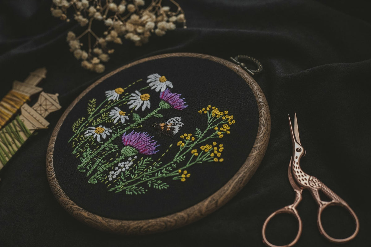 Broderie sur tissu noir avec ciseaux d'atelier